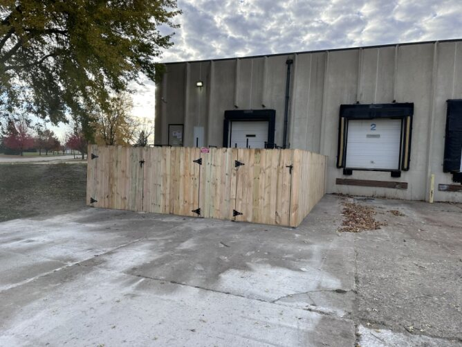 Wood fence enclosure installed around a commercial loading dock area for security and privacy.