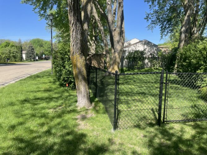 Chain link fence enclosing a large open field or sports area