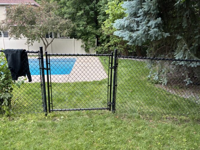 Chain link fence enclosing a large open field or sports area