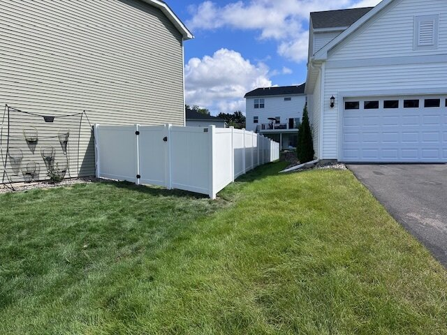 White vinyl privacy fence installed around a residential property